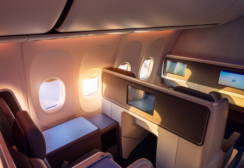 Modern airplane interiors, luxury first class and business class seats with entertainment area.