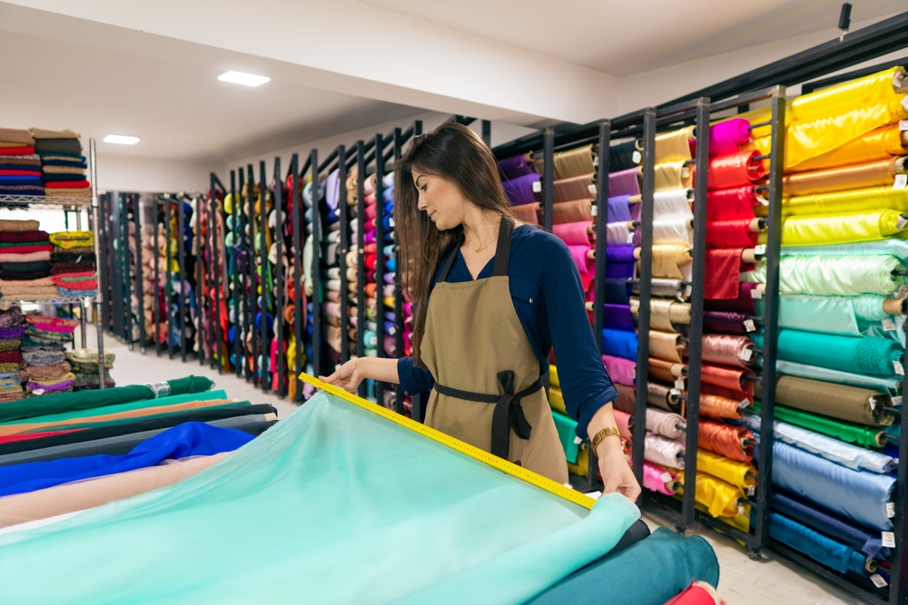 brazilian store seller measuring fabric for sale inside store