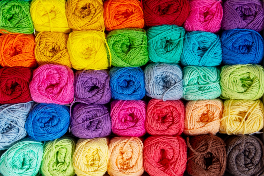 Background of colorful balls of wool threads for knitting, vibrant colors pattern, material for handmade items, hand knitting and needlework