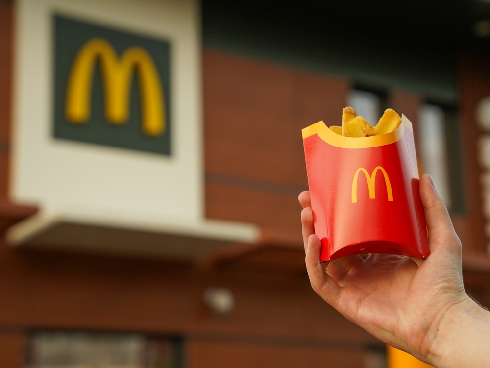 Lviv, Ukraine - April 11 2024: French fries in McDonald's Restaurant. A hand with McDonald's french fries outdoors, closeup