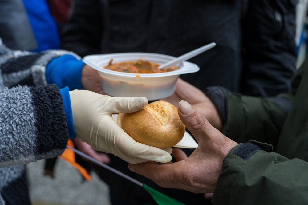 Cologne, North Rhine-Westphalia, Germany – December 22 2023: Volunteers from Juttas Suppenküche e.V. serve soup, food and gifts to homeless and people in need at the Domforum