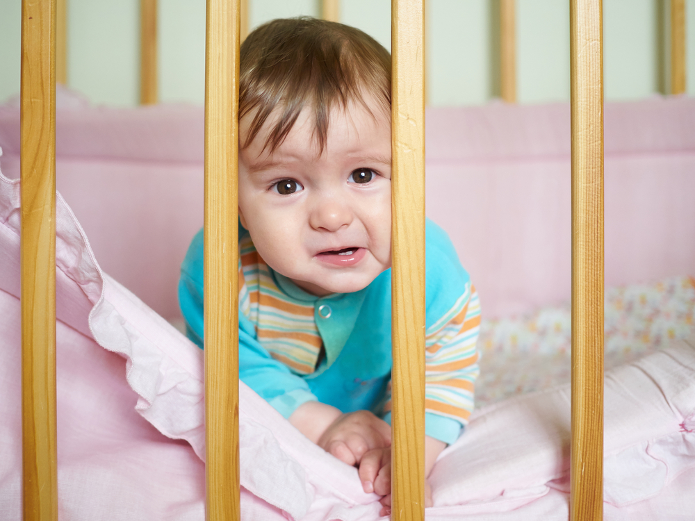 Little baby in a cot. Portrait child baby close up.
