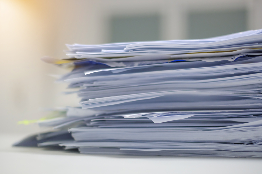 Document pile on office desk, Stack of business paper on the table with blurred of meeting room interior background. job interview and busy business concepts.