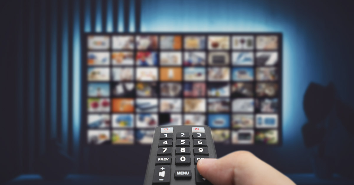TV remote pointing at flat screen TV displaying a streaming service