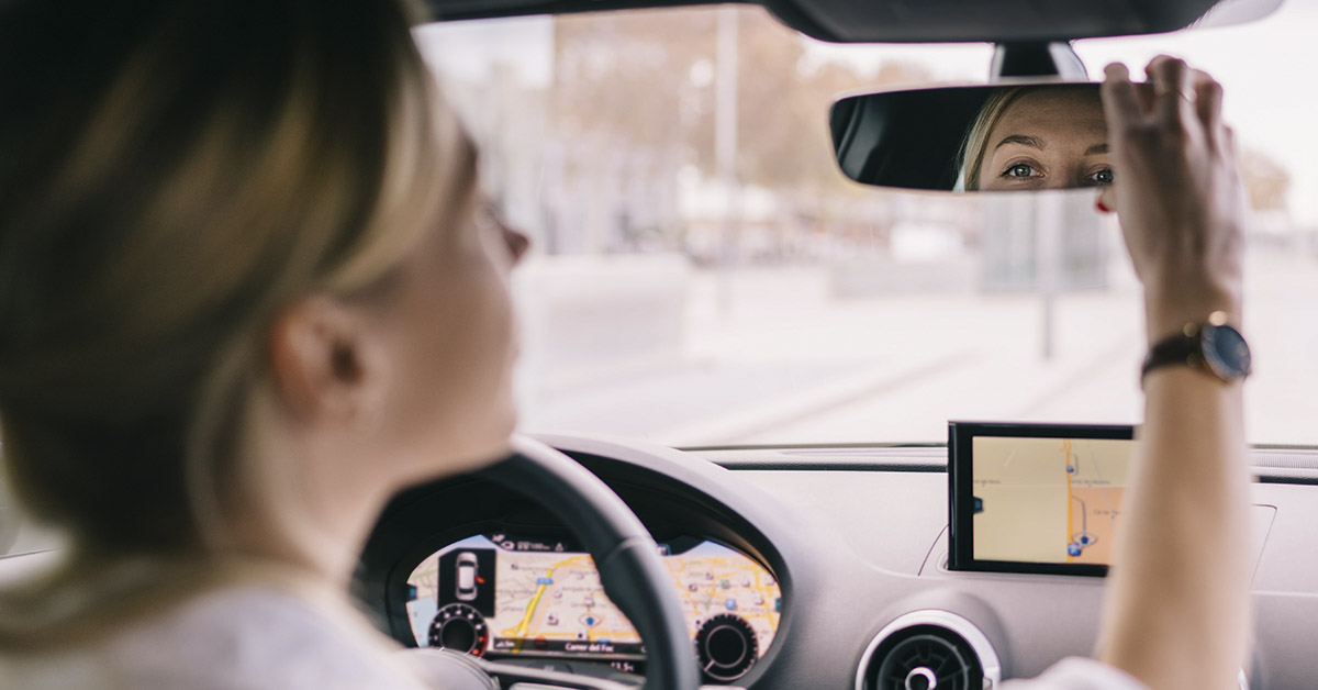 woman looking in rear view mirror
