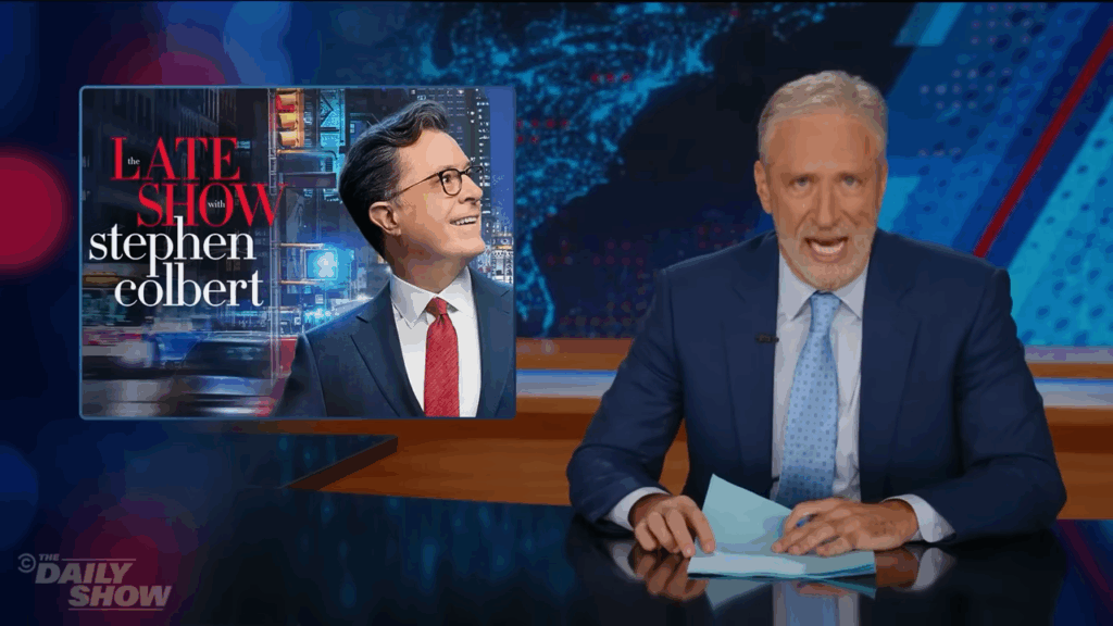 Stewart displaying a photo of Stephen Colbert on screen while discussing CBS's cancellation of The Late Show during his response segment.