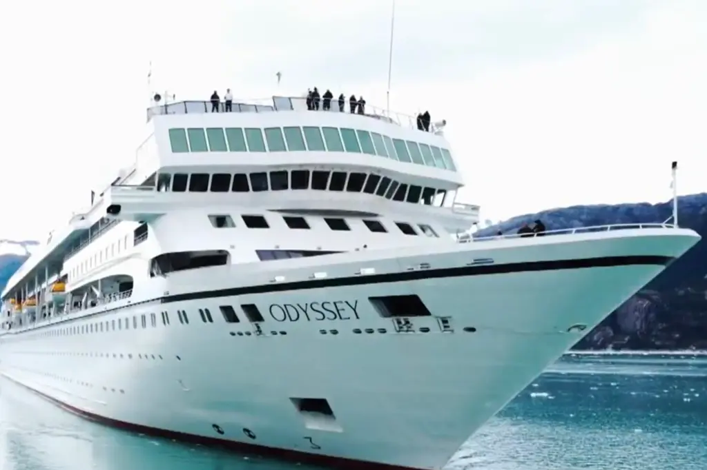 People stand on the top deck of the Odyssey during sailing.