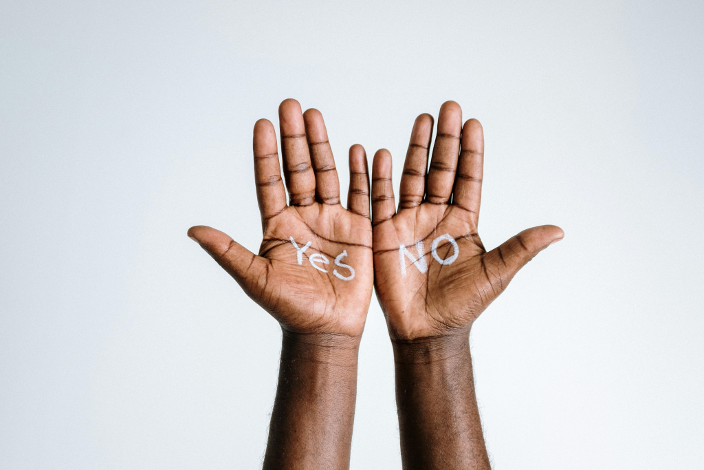 Open palms displaying "YES" and "NO," symbolizing the internal struggle with boundaries and decision-making.