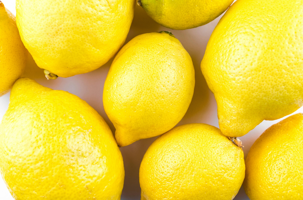 Fresh yellow lemons clustered together.