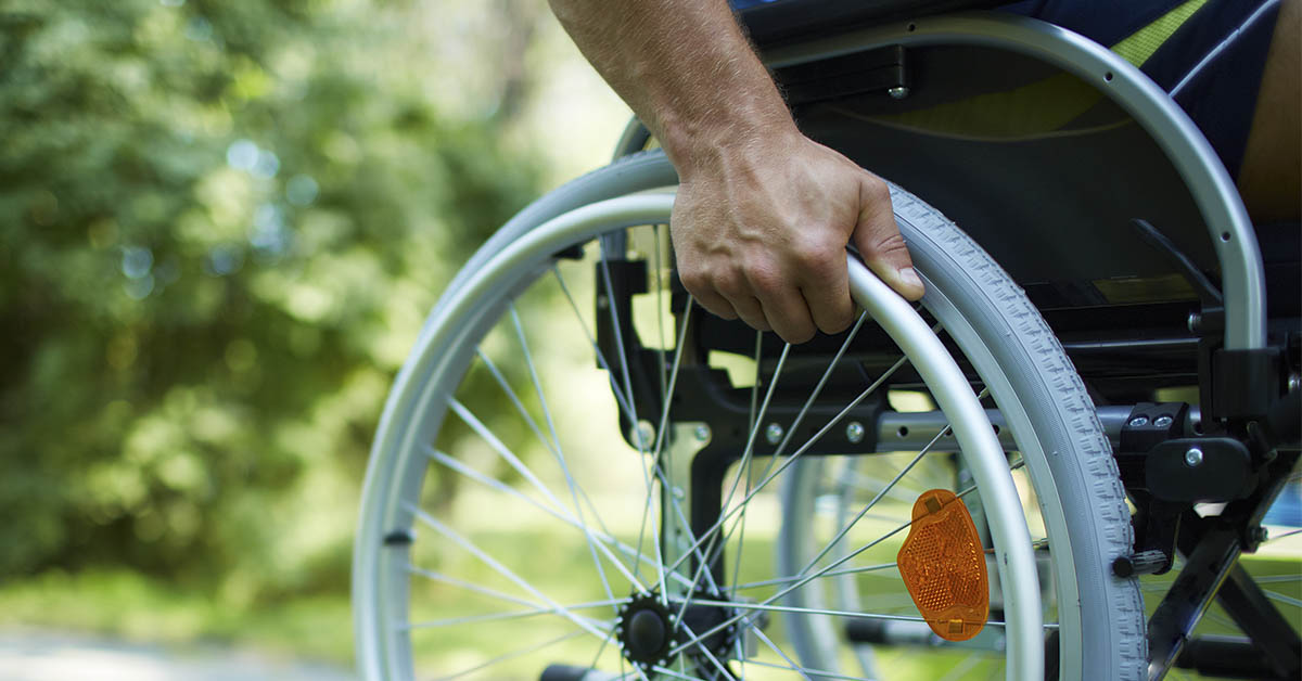 man in wheel chair holding wheel