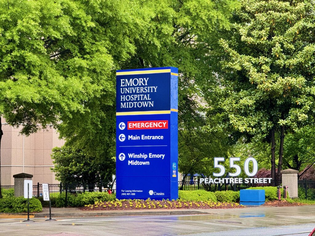 Blue Emory University Hospital sign showing emergency entrance and main entrance directions at 550 Peachtree Street.