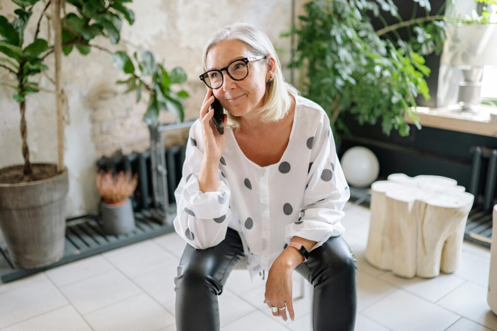 Woman in Polka Dot Shirt Talking on Phone