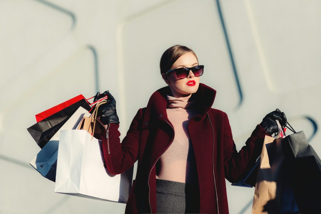photo of woman holding white and black paper bags
