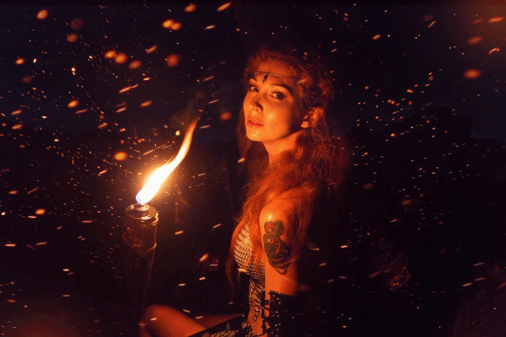 Woman Sitting Beside Lit Torch
