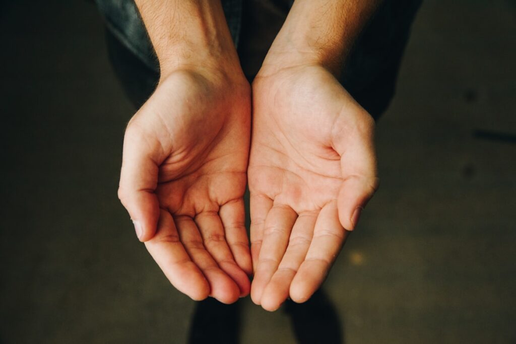 Open hands cupped together in giving gesture, showing generosity and offering support.