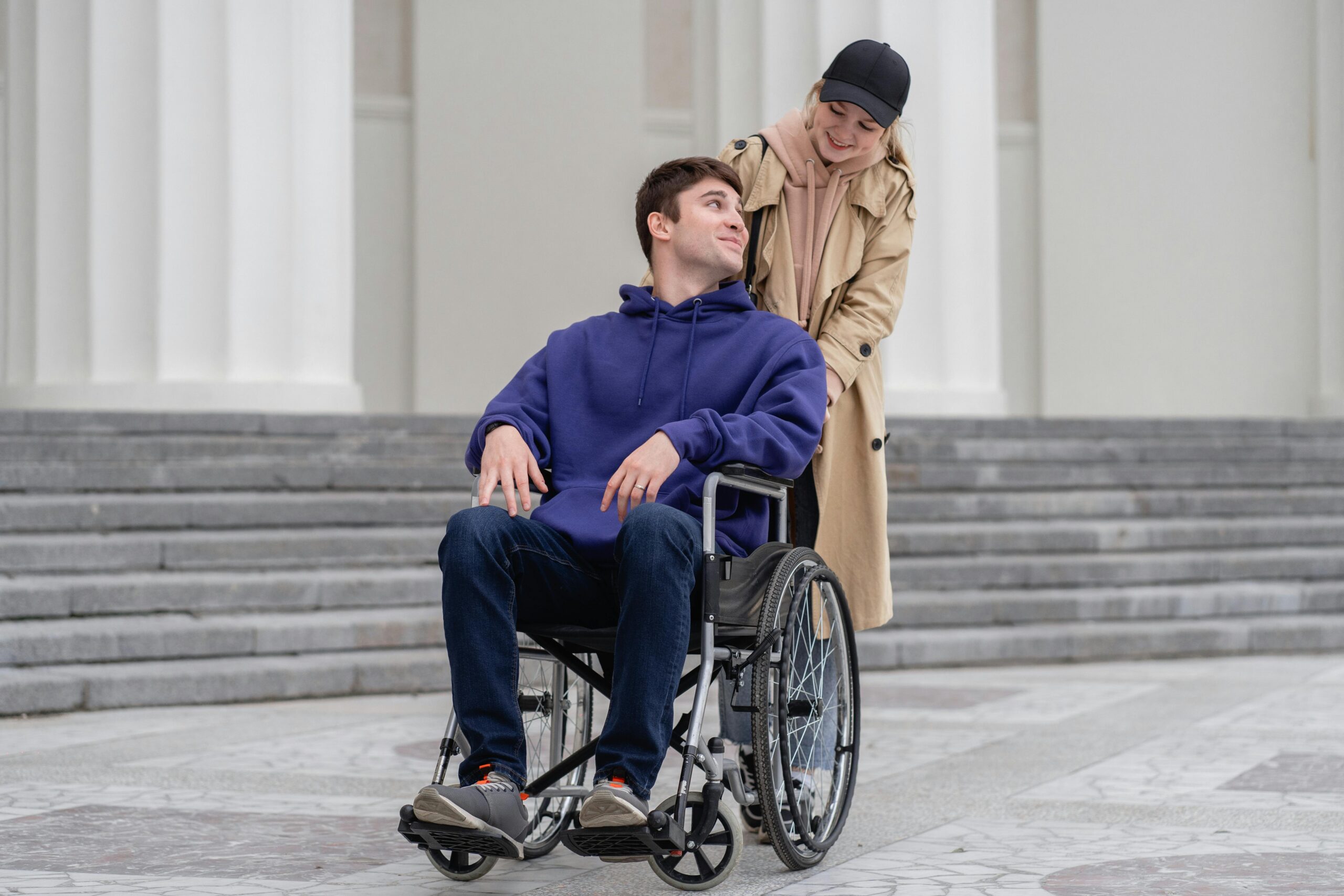 Woman Pushing a Man Sitting on a Wheelchair