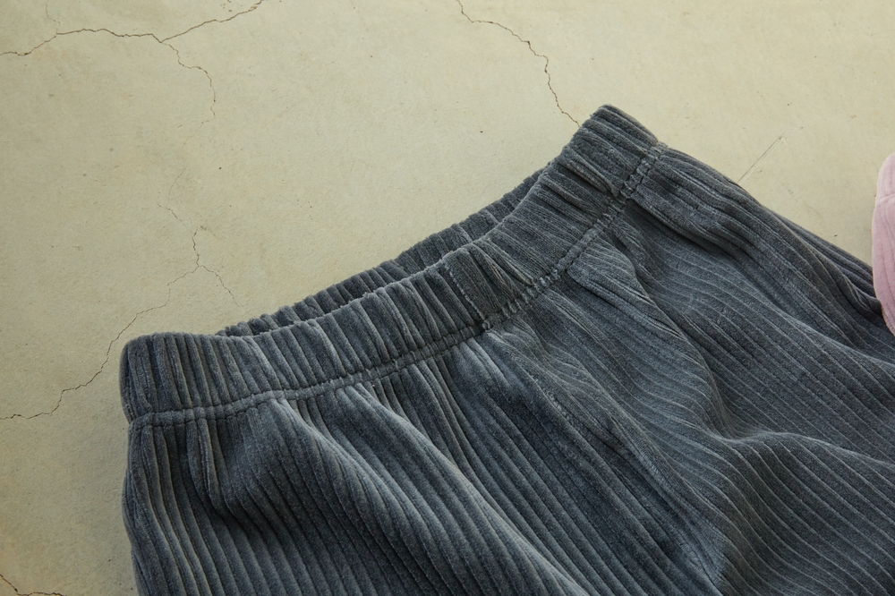 Dark gray pants` elastic waistband.Close view on gray pants. Elastic waistband and adjusting drawstring.