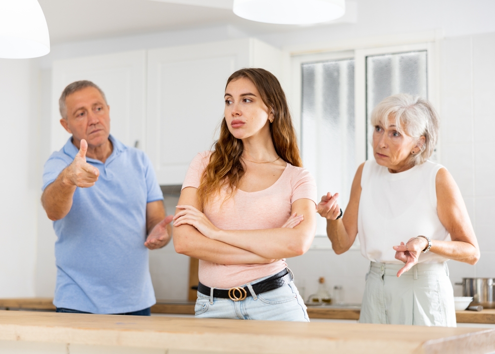 Parents lecturing their adult daughter at home

