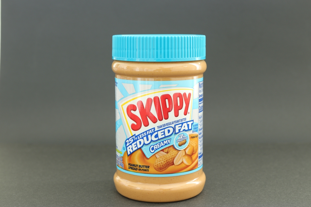 MIAMI, FLORIDA USA - 06-05-2024
Single jar of Skippy peanut butter isolated against dark background.