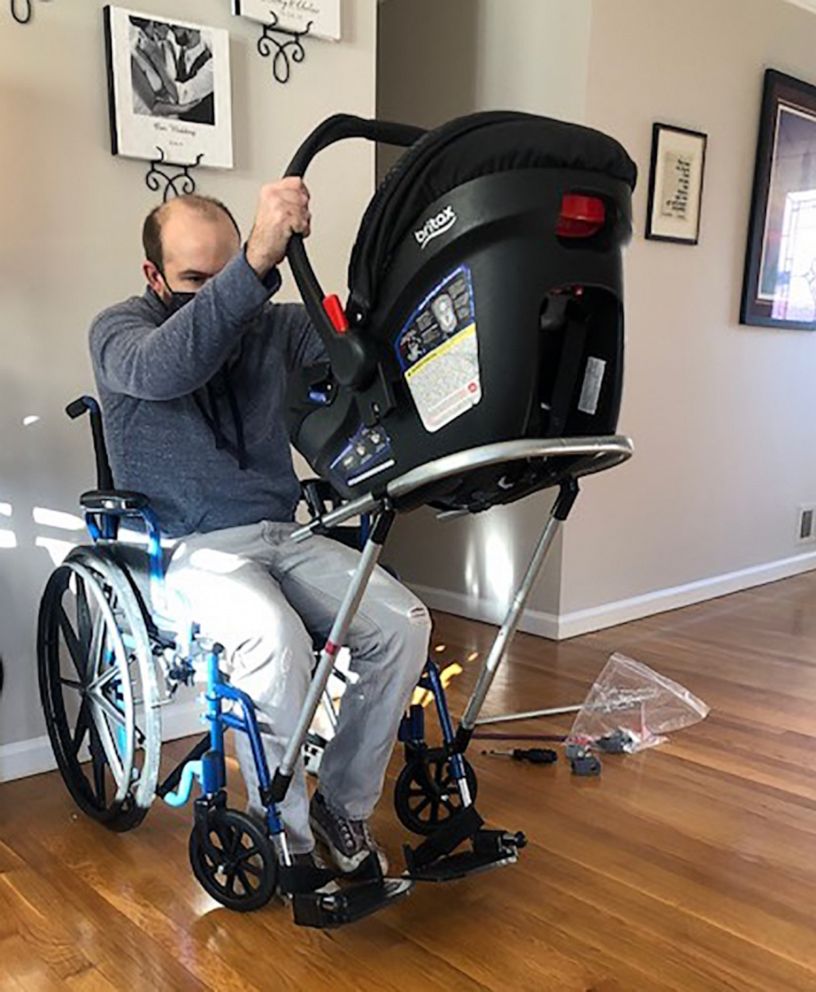 Jeremy King attaching his son's car seat to his wheelchair at their Germantown, Md., home.