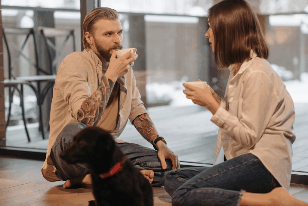 Couple Drinking Coffee Sitting Beside a Dog