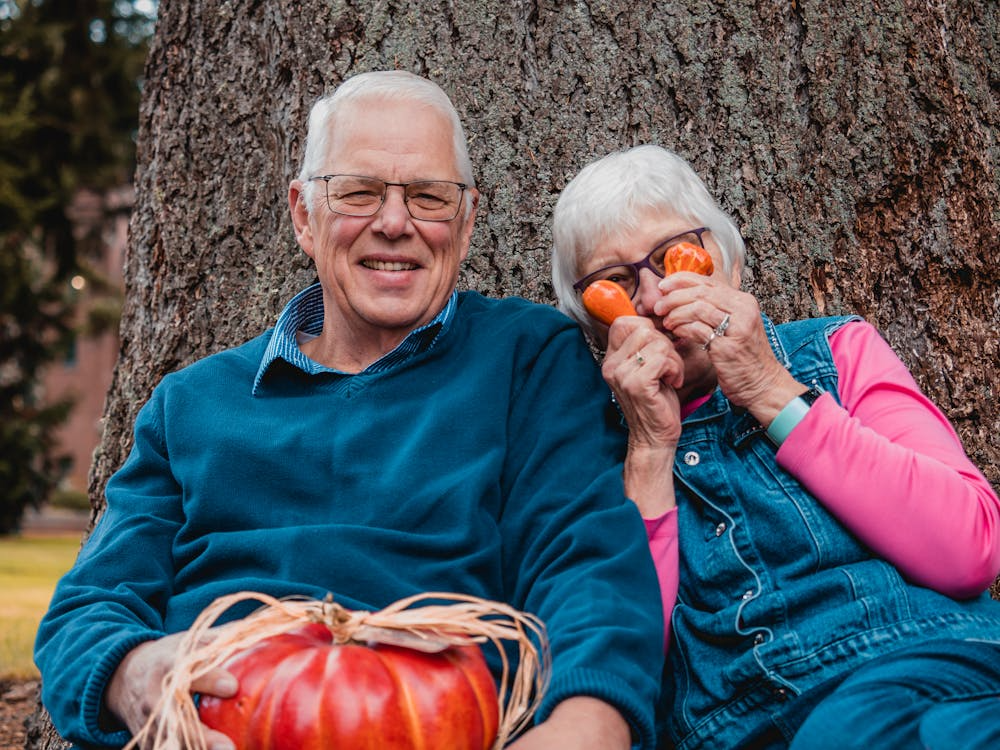 Elderly Couple Leaning on Tree Trunk
