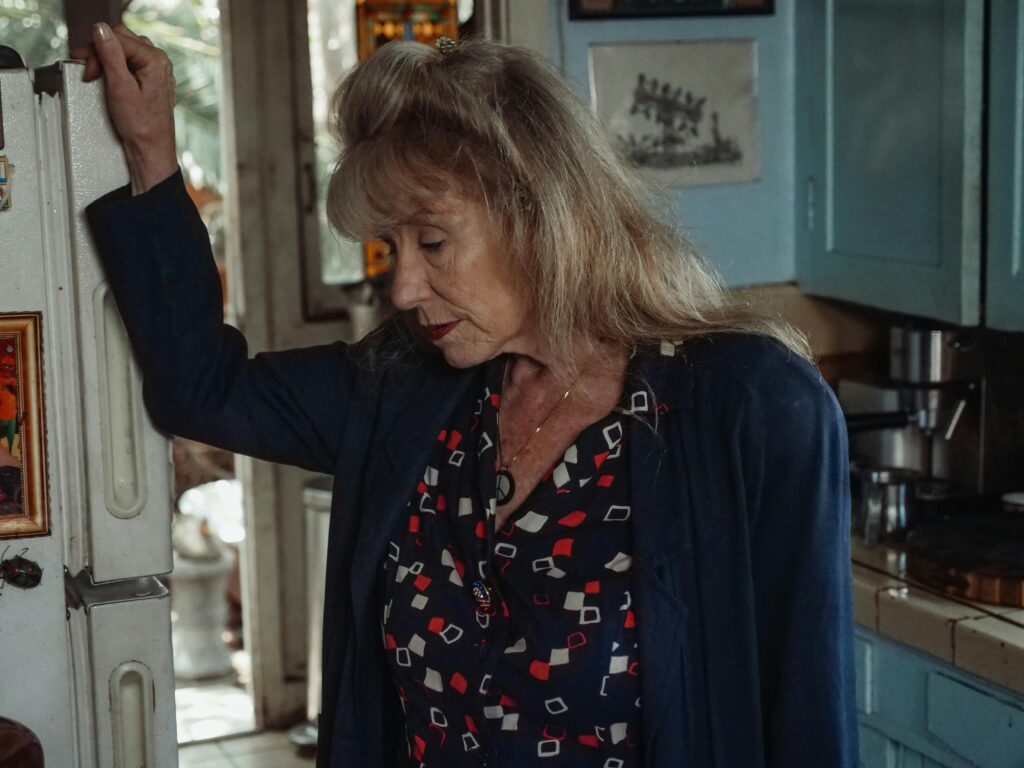 Woman standing confused in kitchen, demonstrating how early signs of dementia make familiar tasks difficult.