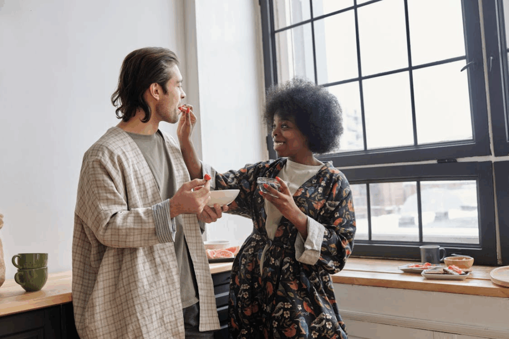 Woman Feeding Strawberries to a Man and Smiling