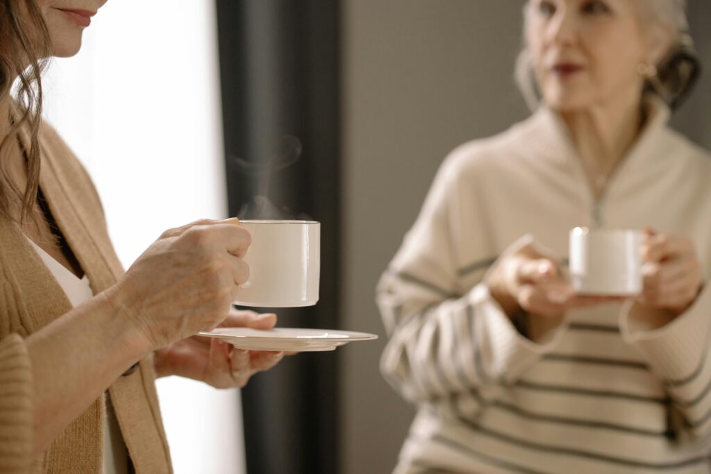 Two women having coffee, representing social connections that become challenging.