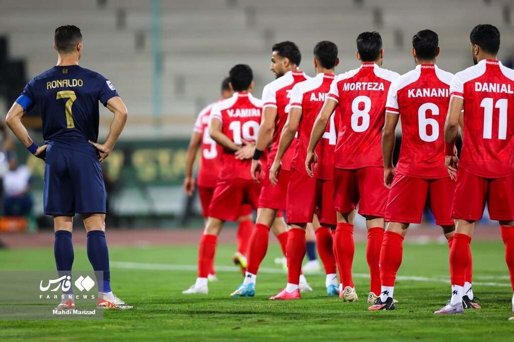 Cristiano Ronaldo in dark blue kit preparing to take a free kick with defensive wall of players in red and white uniforms.