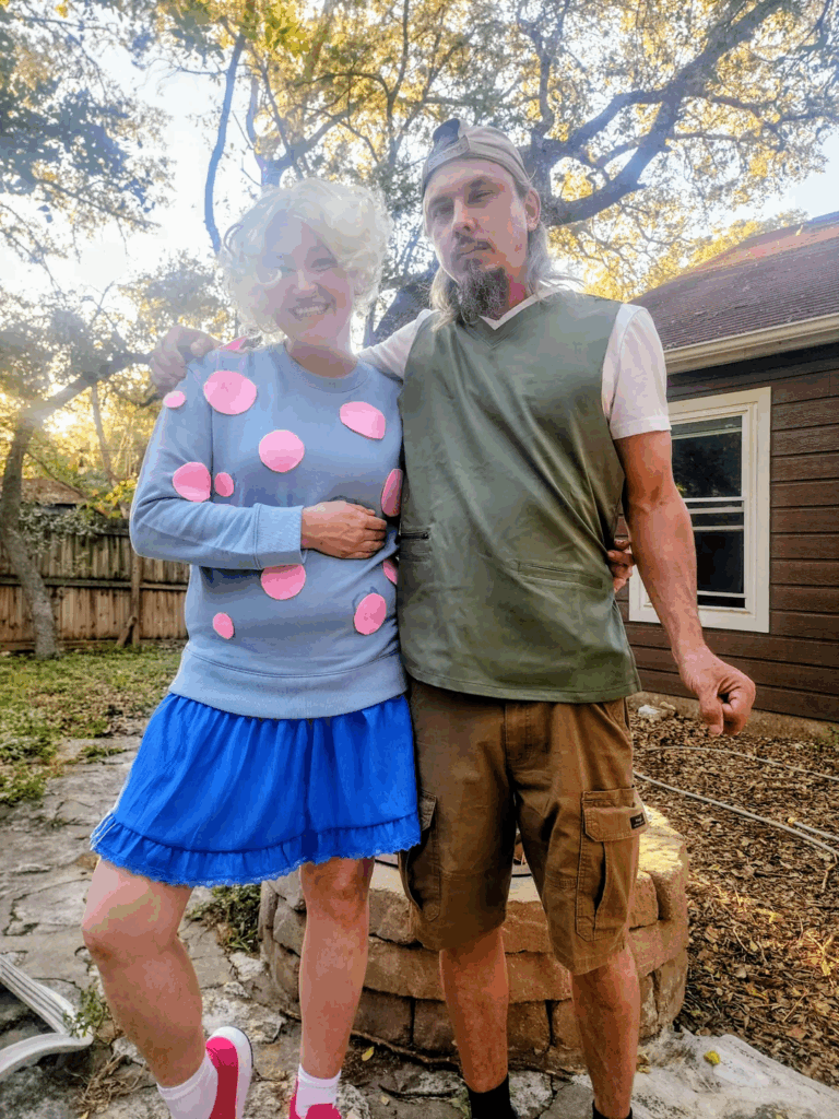 woman in blonde curly wig and polka dot sweater standing next to man outside