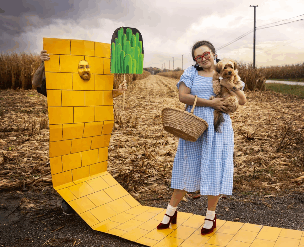 man with yellow cardboard next to wife in blue dress holding dog