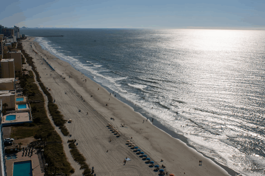 Colorful umbrellas line Myrtle Beach, where ocean waves meet a bustling boardwalk full of summer energy.