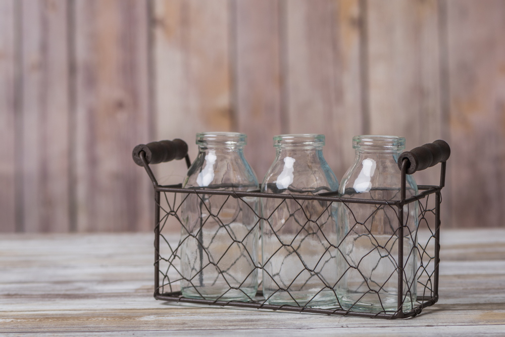 Old milk bottles in carrier with wood background