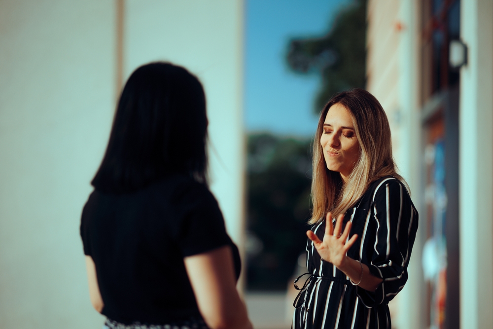Woman Listening to her Friend Lies Making Stop Gesture
Girl not trusting her manipulative best friend blocking communication