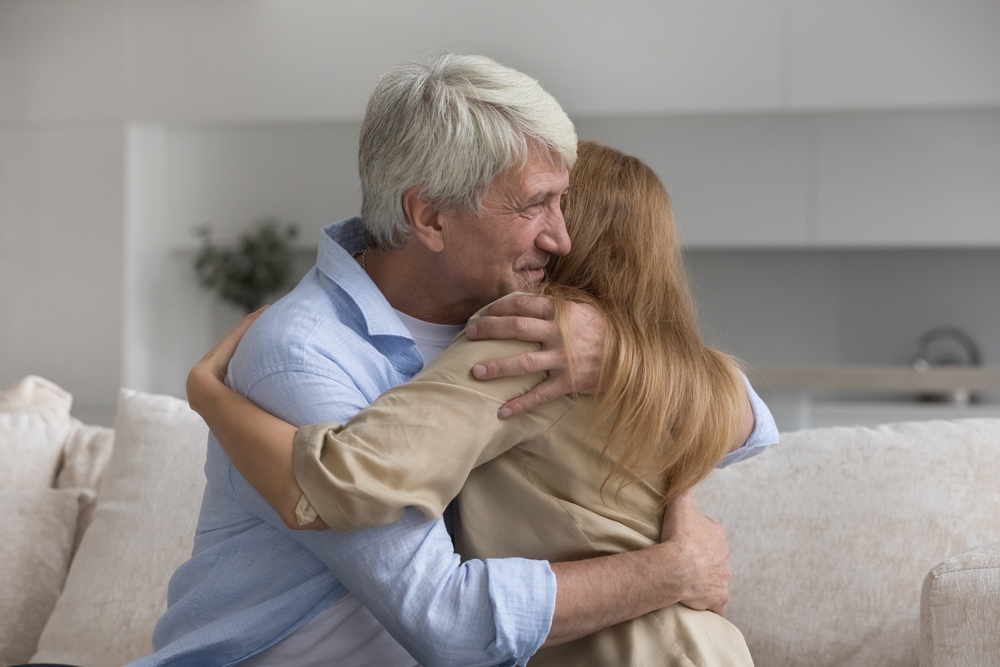 Happy caring loving old daddy hugging adult daughter child, smiling, giving comfort, support, sympathy. Woman congratulating dad on fathers day, enjoying meeting, warm relationship