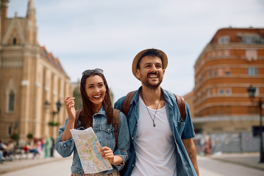 Happy couple walking through the town during their summer travel. Copy space. 