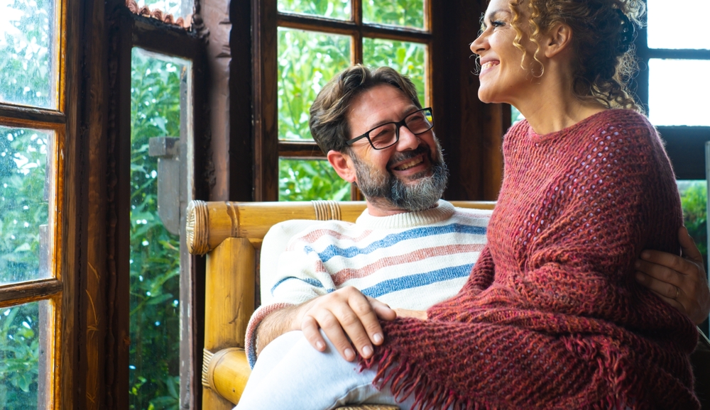 Mature couple in their 40s sharing affection at home or in a cozy vacation chalet. A moment of love, trust, physical closeness and emotional connection built on honesty, intimacy, respect and understa