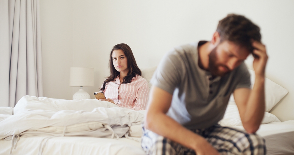 Frustrated woman, argument and conflict with stress in bed for cheating affair or disagreement. Upset, person or toxic relationship with phone in bedroom dispute for divorce or trust issues in home
