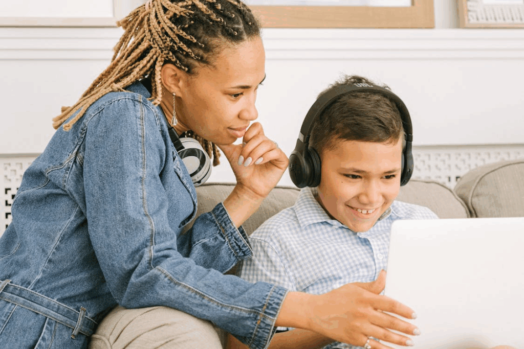 Woman in Blue Denim Jacket Holding White Tablet Compute