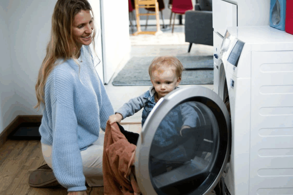 A Woman and Baby Girl Looking the Washing Machine
