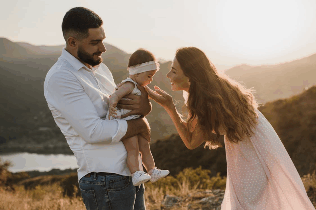 Smiling Father in Shirt and Mother in Sundress with Baby