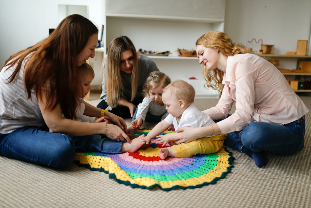 Group of mothers with babies in a lesson at a kindergarten center, Montessori kindergarten mom and baby, caucasian women with children