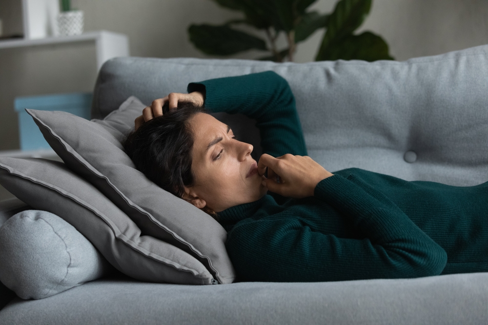 Frustrated anxious unhappy young woman lying on couch, lost in negative thoughts, pondering problem solution, suffering from loneliness or personal psychological troubles, depression concept.