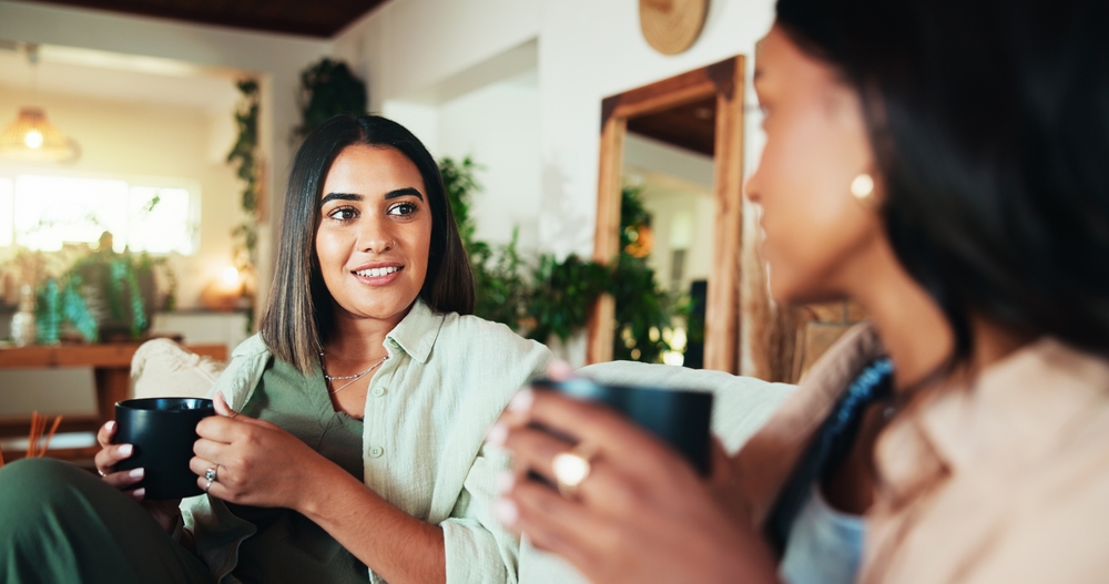 Advice, coffee and friends with women on sofa for bonding, relax and social reunion. Discussion, caffeine and drink with people talking in living room at home for chat, news and connection together