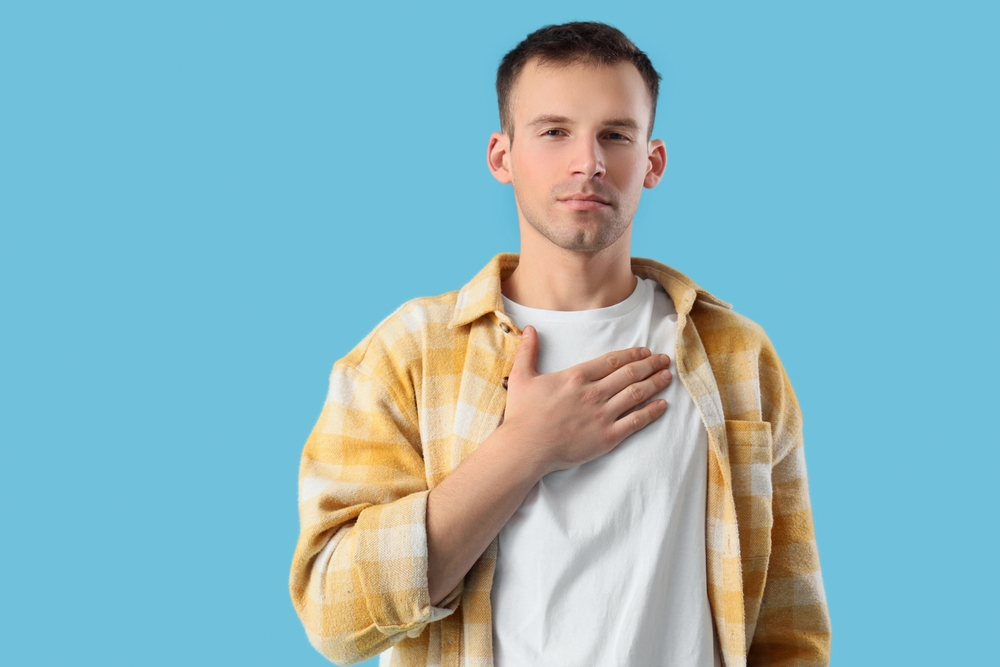 Apologizing young man on blue background