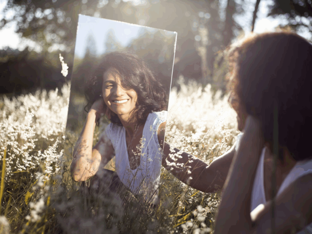 woman looking at mirror in field