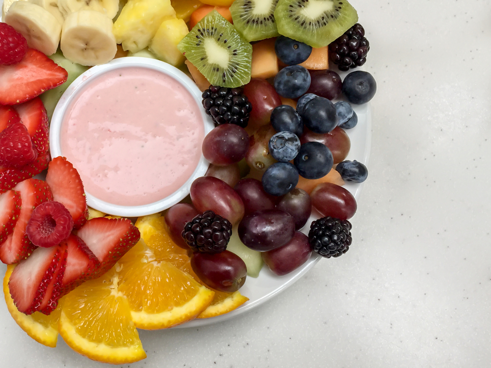 Vibrate healthy fruit plate with creamy dip