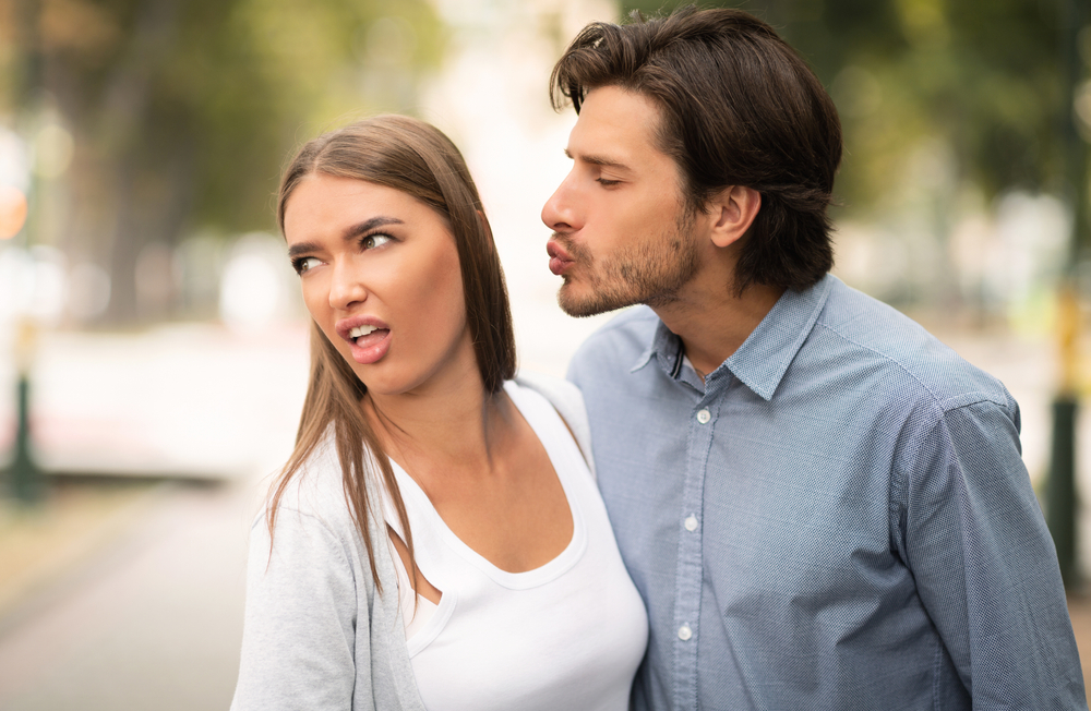 Disgusted Woman Rejecting To Kiss Man Having Bad Date Walking Outdoors In Park. Unanswered One-Sided Love Concept