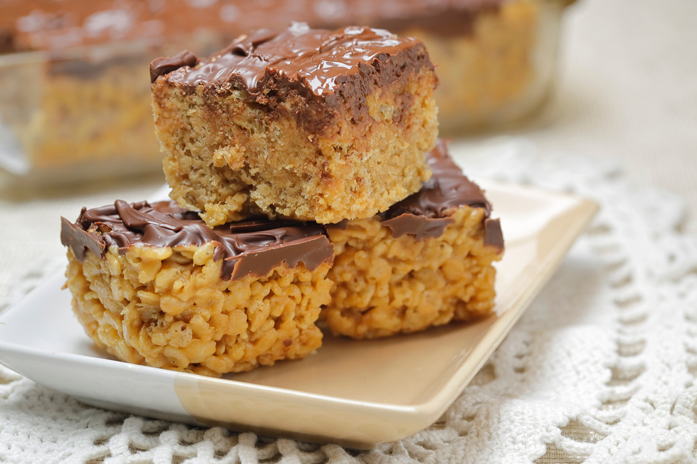 A close up of three rice krispie treats on a plate.